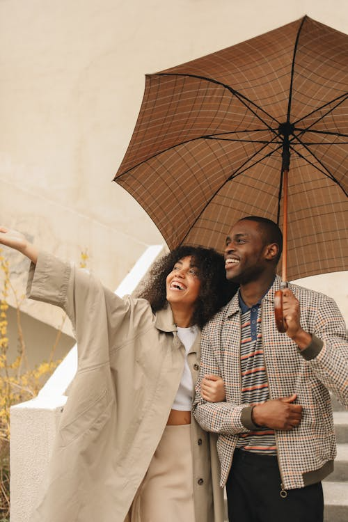 Happy travelers with luggage at airport, protected by comprehensive travel insurance